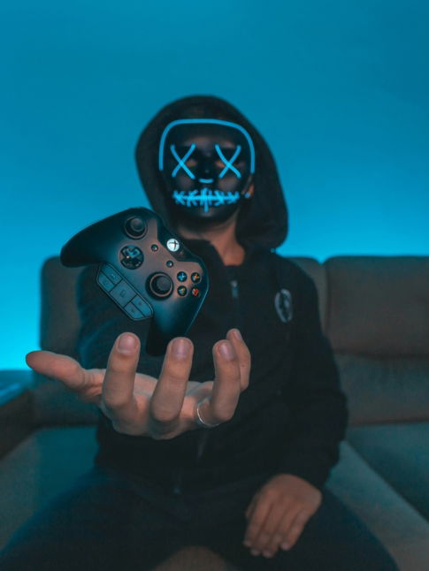 person sitting on chair while holding Xbox One controller